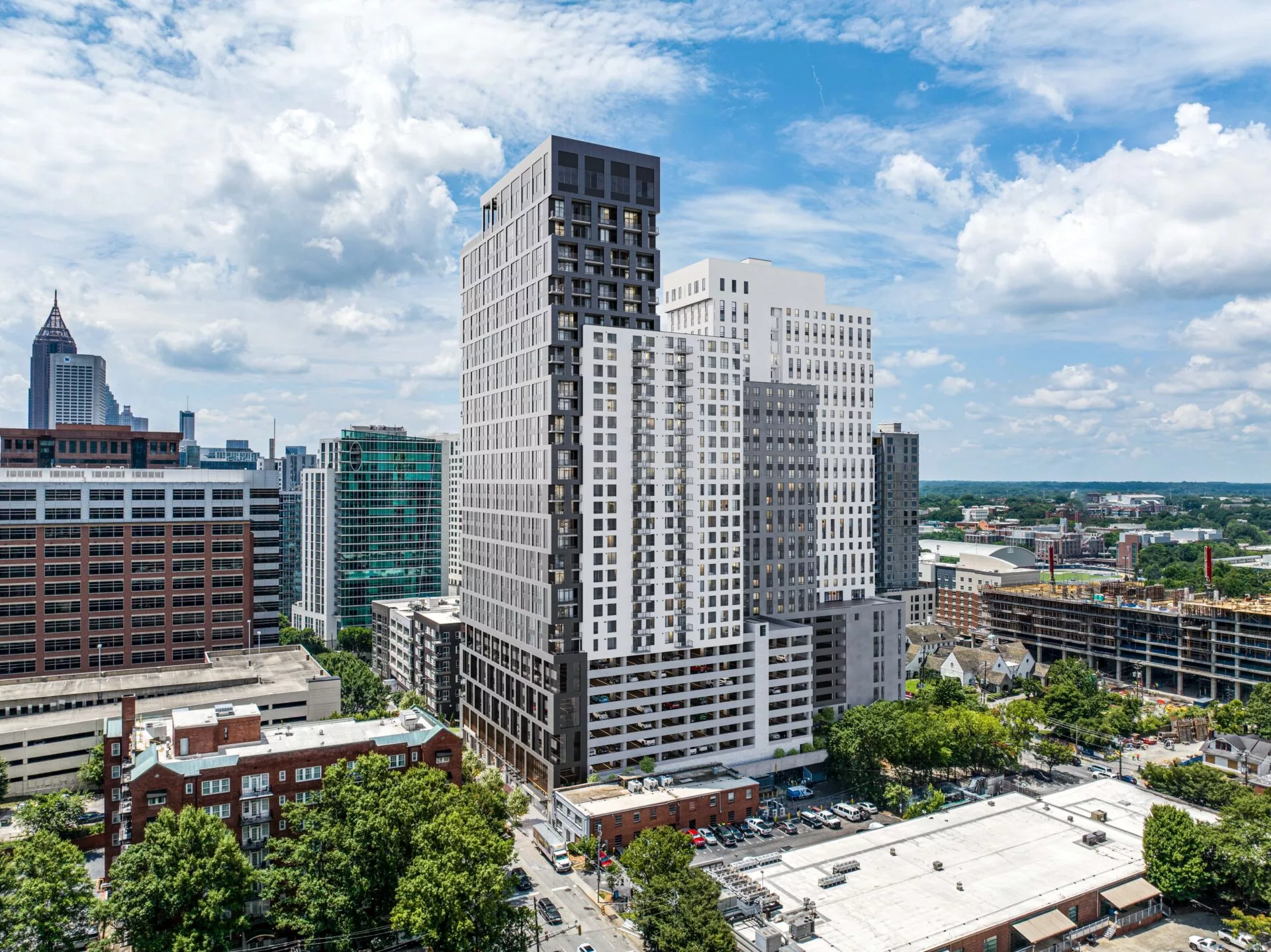 A modern high-rise apartment building with sleek glass windows, viewed during the day.